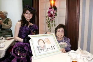 結婚式でおばあちゃんと似顔絵を持って記念撮影